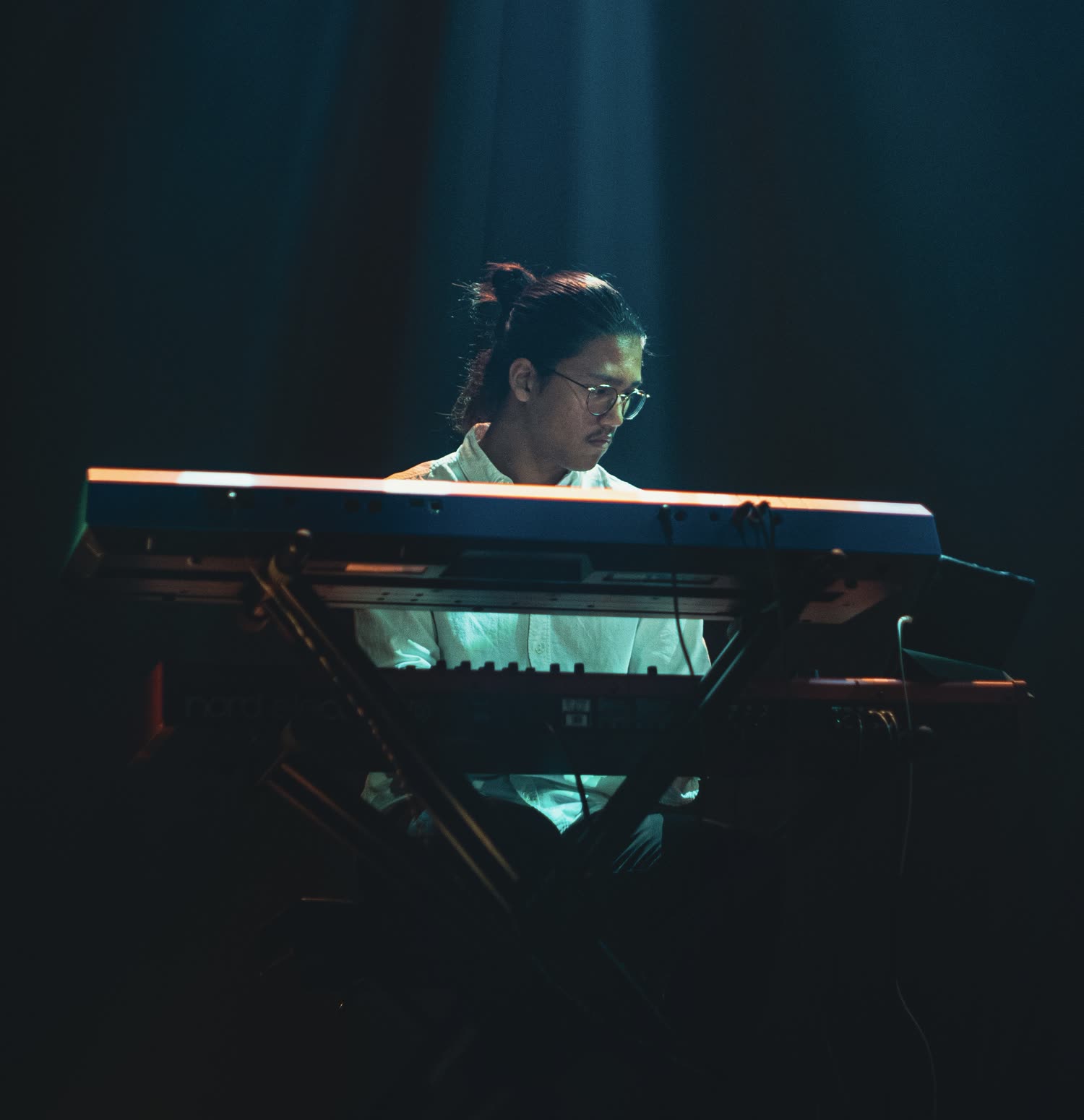 Oliver Smith achter de toetsen onder een spotlight