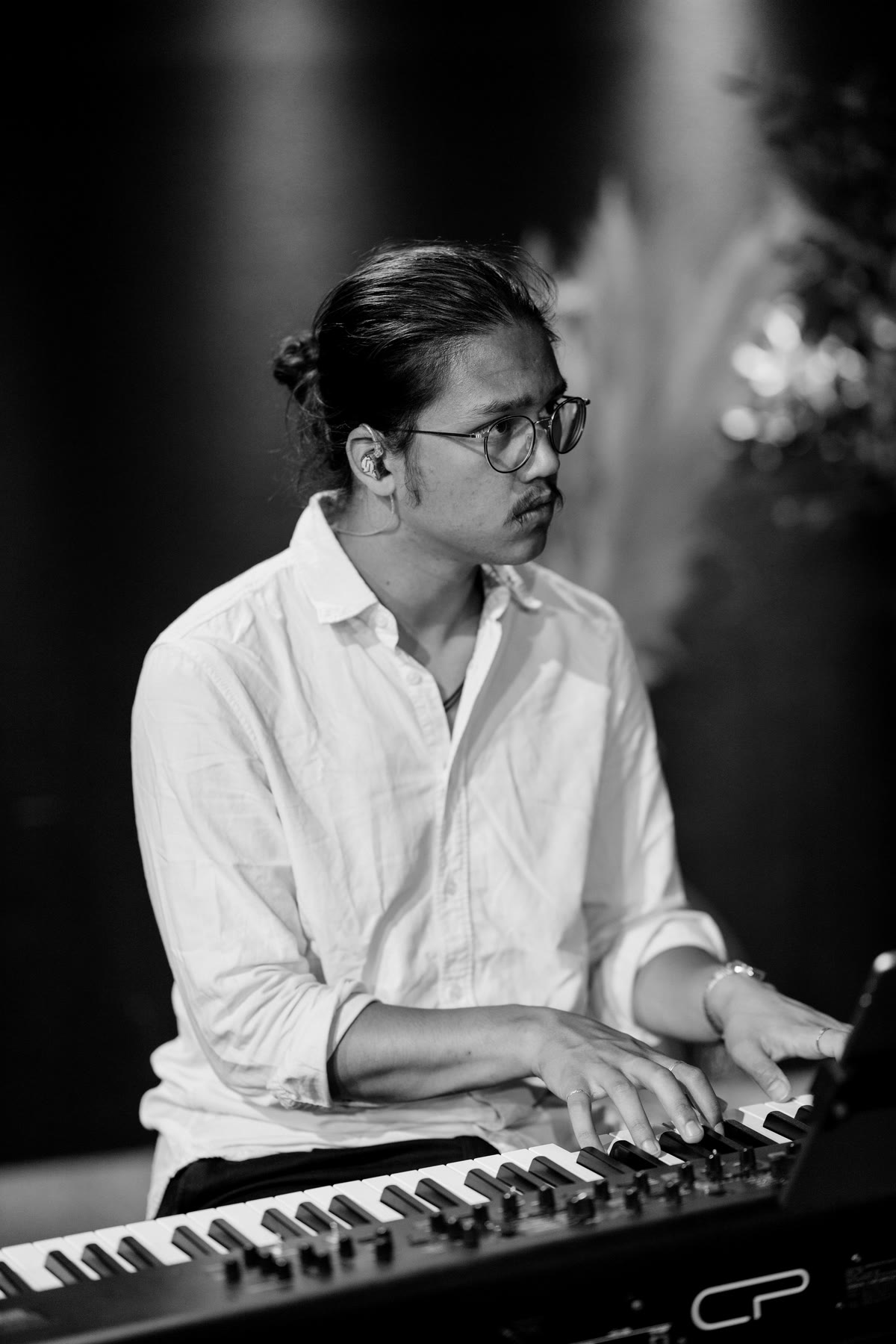 Oliver Smith achter zijn keyboard tijdens een optreden, zwart-witfoto